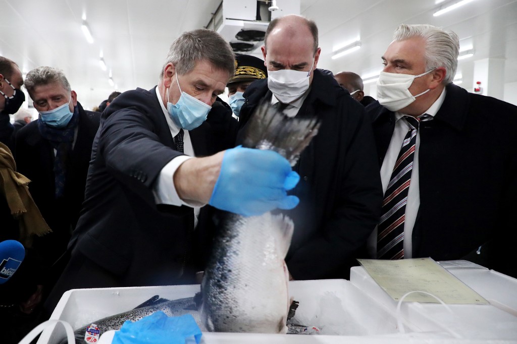 Le Premier ministre français Jean Castex, flanqué du maire de Boulogne sur Mer, Frédéric Cuvillier, rencontre différents représentants du port de pêche lors d'une visite sur les préparatifs en vue de la fin de la période de transition du Brexit le 31 décembre, 2020, à Boulogne sur Mer, France, le 3 décembre 2020 (AFP)