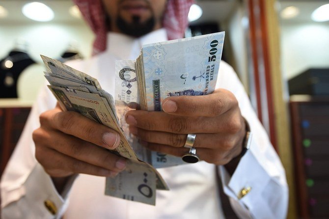 Un homme compte des billets en riyal saoudien dans sa bijouterie au marché de Tiba à Riyad, le 3 octobre 2016. (Photo/AFP)