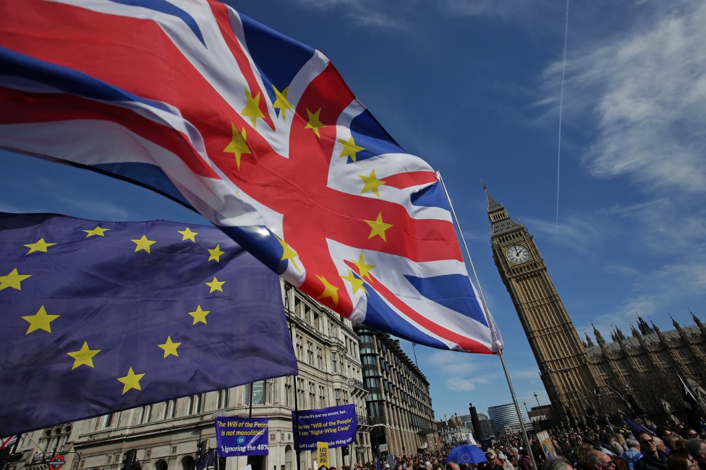 Une photo prise le 25 mars 2017. Des manifestants tenant des drapeaux de l'UE et de Royaume-Uni se rassemblent devant les Chambres du Parlement sur la place du Parlement à la suite d'une marche anti-Brexit et pro-Union européenne (UE) à Londres. (AFP)