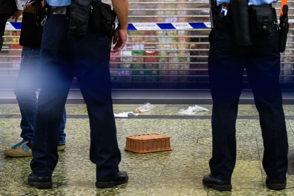 La police monte la garde à côté d'un utilisé pour couvrir un couteau et d'autres preuves dans une zone bouclée de la station de métro Sham Shui Po MTR à Hong Kong le 7 novembre 2018, après que la police a abattu un homme tenant un couteau après qu’il ait tenté de les attaquer, selon des responsables. (AFP)