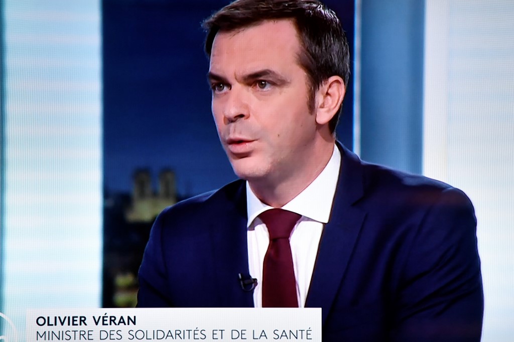 Le ministre français de la Santé et de la Solidarité, Olivier Veran, est vu sur un écran de télévision alors qu'il participe au journal télévisé du soir sur la télévision publique française France 2 le 29 décembre 2020, à Paris, au milieu de la pandémie de Covid-19, causée par le nouveau coronavirus. (AFP)