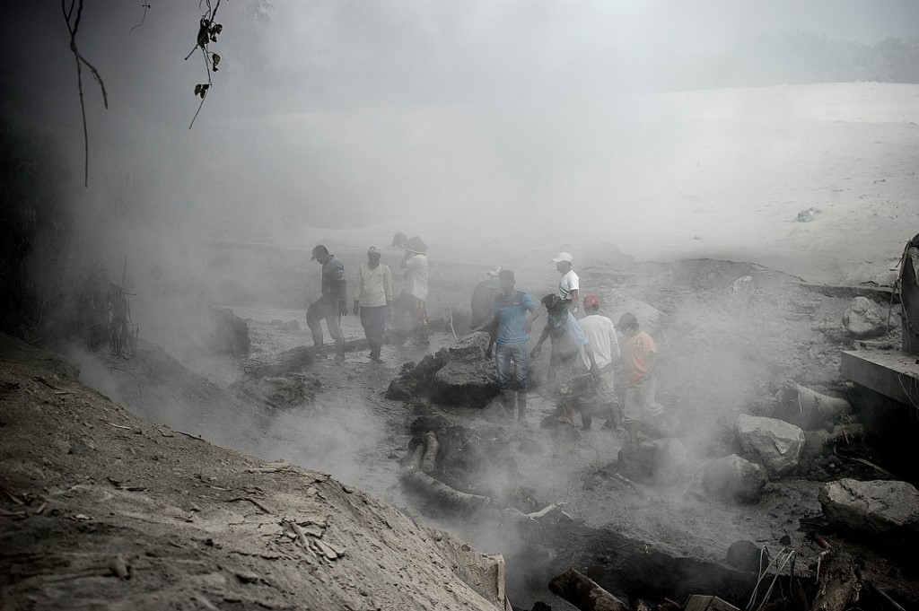 Les villageois se rassemblent pour vérifier les dégâts causés par les coulées de lave à Lumajang, dans la province de Java oriental, à la suite de l'éruption du volcan du mont Semeru. (AFP)