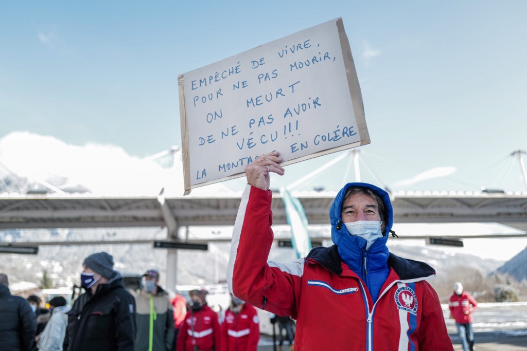Un manifestant tient une pancarte demandant la réouverture de la station de ski dans les Alpes françaises pour les vacances de Noël. (AFP)