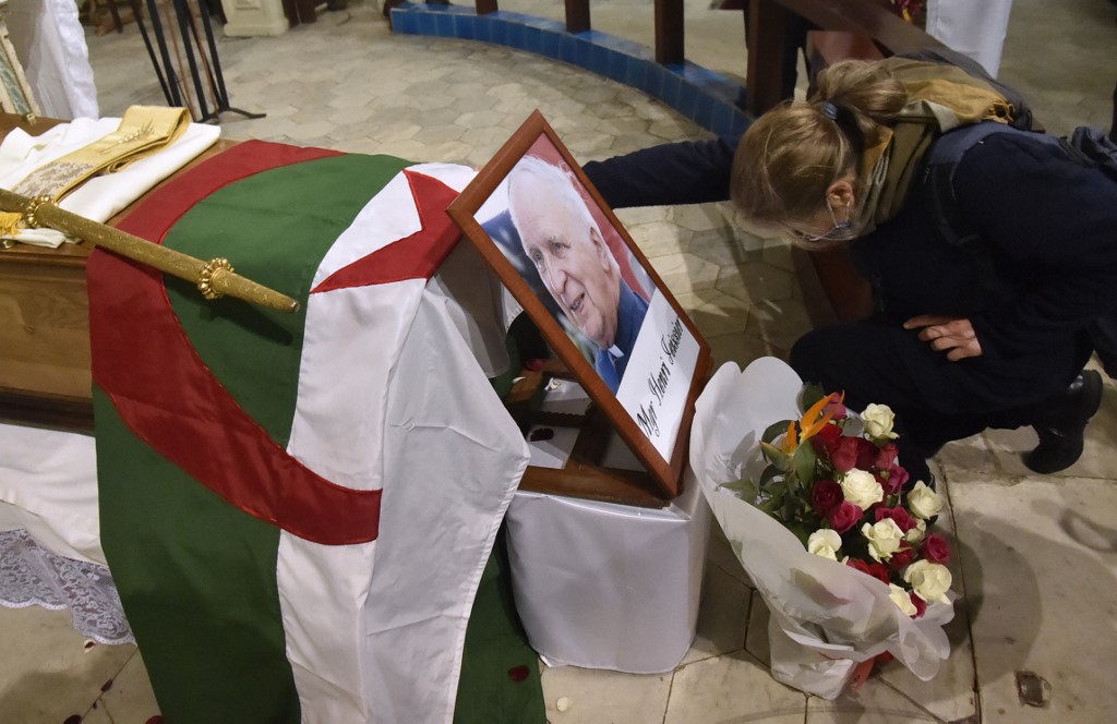 Une femme à genoux près du cercueil de feu l'archevêque algérien Henri Teissier à la cathédrale Notre-Dame d'Afrique à Alger le 8 décembre 2020 à la veille de ses funérailles. Teissier est décédé à l'âge de 91 ans en France (Photo, AFP)