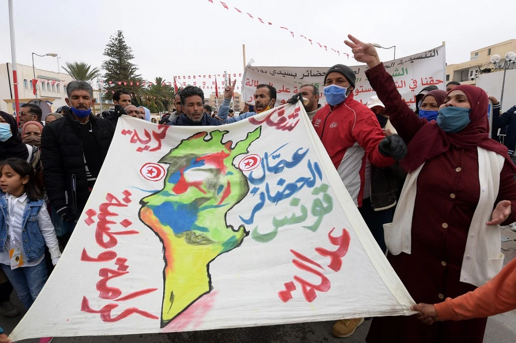 Des Tunisiens scandent des slogans alors qu'ils se rassemblent sur la place Mohamed Bouazizi dans la ville tunisienne Sidi Bouzid, le 17 décembre 2020. (AFP)