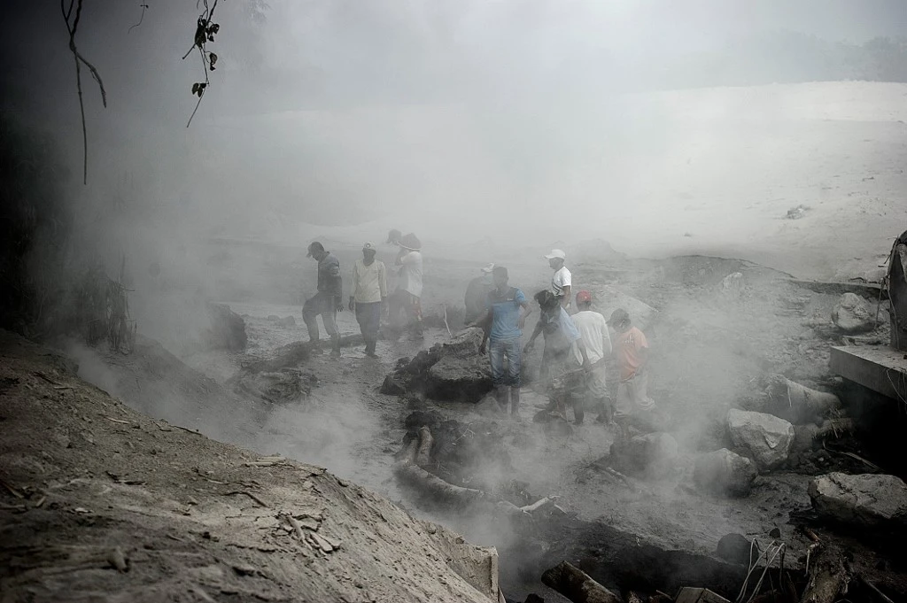 Les villageois se rassemblent pour vérifier les dégâts causés par les coulées de lave à Lumajang, dans la province de Java oriental, à la suite de l'éruption du volcan du mont Semeru. (AFP)