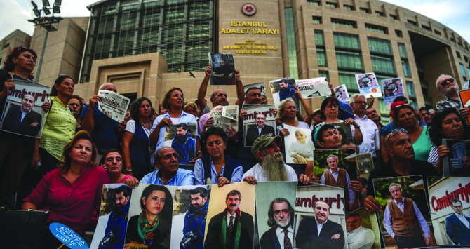 Des manifestants brandissent des photos de journalistes détenus lors d'une manifestation devant le palais de justice d'Istanbul. Un rapport publié récemment met en évidence les violations répétées des droits de l'homme en Turquie. (AFP/Dossier)