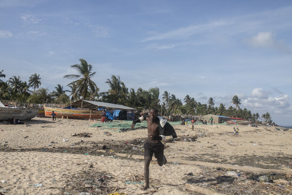 Un jeune homme saute le 11 décembre 2020 à la plage de la communauté de Paquitequete, un lieu où des milliers de personnes déplacées sont arrivées ces derniers mois, fuyant les attaques d'insurgés armés dans différentes zones de la province de Cabo Delgado, au nord du Mozambique. (AFP)