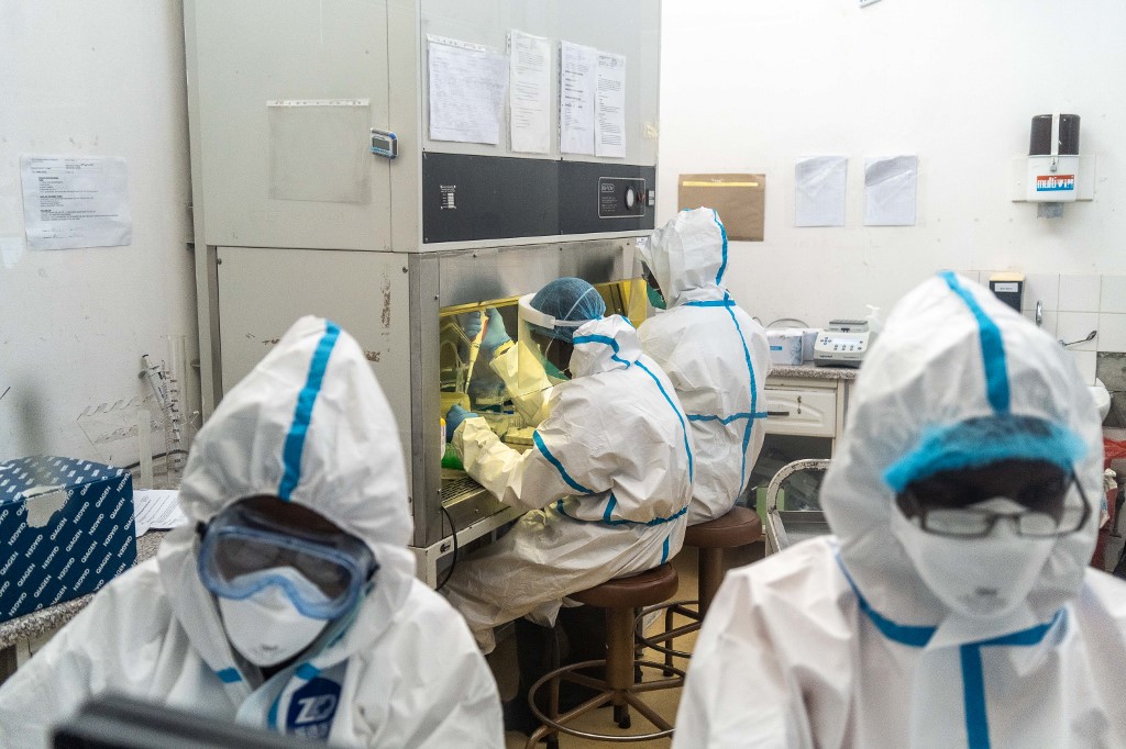 Des membres de l'Université nationale des sciences et technologies (NUST) travaillent dans un centre de test de laboratoire COVID-19. (AFP)