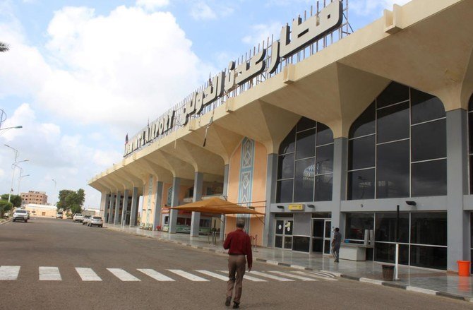 Des gens se tiennent à l'extérieur du bâtiment de l'aéroport à Aden, dans le sud du Yémen, le 3 janvier 2021, alors que l'activité reprend après les explosions qui ont secoué le bâtiment le 30 décembre, tuant ou blessant des dizaines de personnes. (AFP)