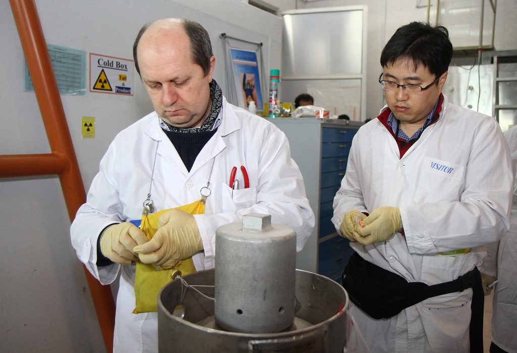 Des inspecteurs non identifiés de l'Agence internationale de l'énergie atomique (AIEA) scellent après avoir déconnecté les connexions entre les deux cascades pour une production d'uranium à 20% au centre de recherche nucléaire de Natanz, à quelque 300 kilomètres au sud de Téhéran, le 20 janvier 2014. (AFP)