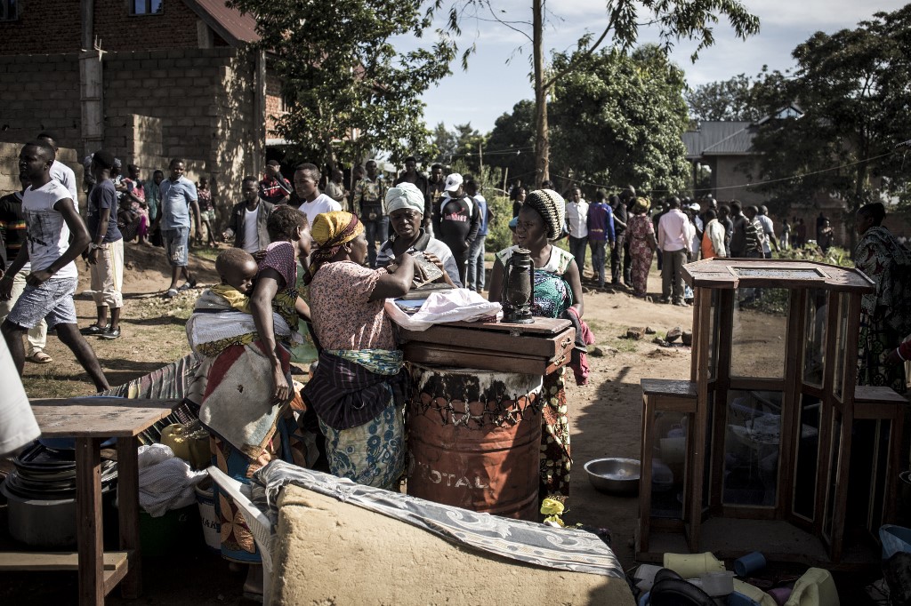 Des femmes congolaises examinent le contenu d'une maison qui aurait été attaquée par les rebelles des Forces démocratiques alliées (ADF), tuant une femme et enlevant quatre enfants et un homme, le 11 novembre 2018 à Beni. (AFP)