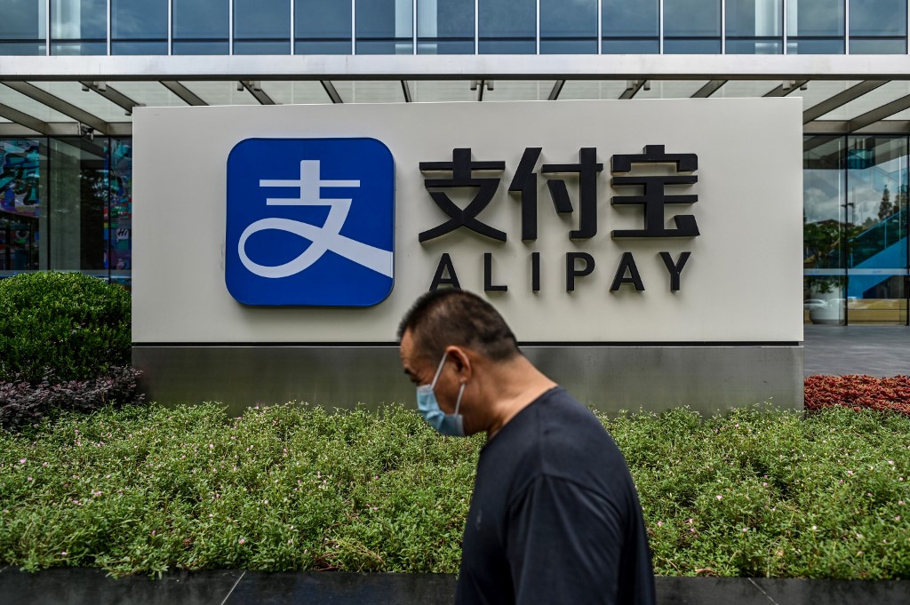 Cette photo d'archive, prise le 28 août 2020, montre un piéton passant devant un logo Alipay dans l'immeuble de bureaux de Shanghai du Groupe Ant à Shanghai. (AFP)