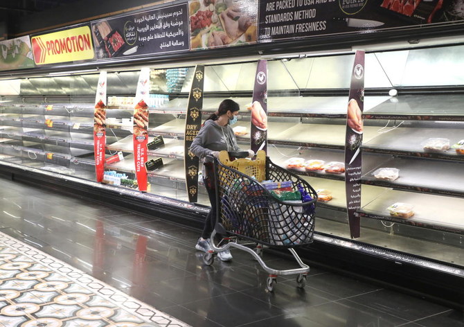 Une cliente pousse son chariot à côté d'étagères presque vides après que des gens aient amassé de la nourriture alors que les autorités discutent des dernières mesures à mettre en œuvre pour freiner la propagation de la COVID-19, à Beyrouth, au Liban, le 11 janvier 2021 (Reuters)