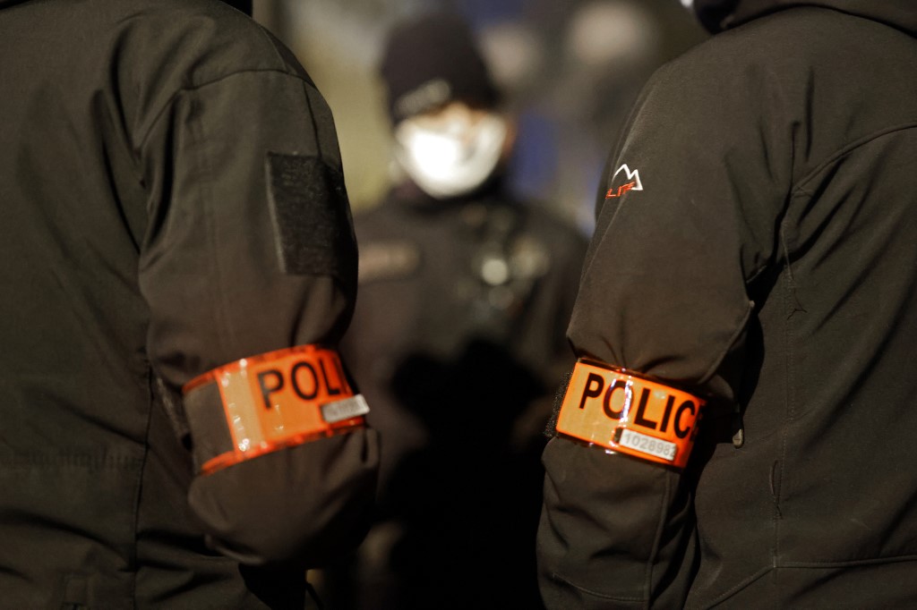 Cette photo prise à Créteil, banlieue sud-est de Paris le 8 décembre 2020 montre des brassards de police alors que des policiers se tiennent devant la Direction territoriale de la sécurité de proximité du Val-de-Marne. (AFP)