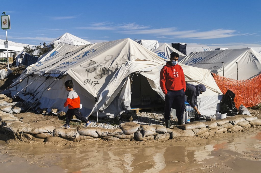 Un migrant se tient devant sa tente, dans le nouveau camp de réfugiés de Kara Tepe, sur l'île de Lesbos, le 19 décembre 2020. (AFP)