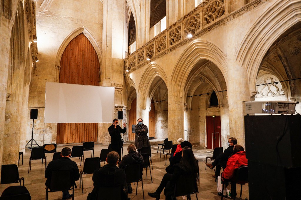 Le directeur du cinéma LUX Gautier Labrusse (CL) prend la parole en présentant le film Michelangelo d'Andrey Konchalovsk qui a été lancé une semaine avant la fermeture des cinémas et est maintenant projeté à l'église du Vieux Saint-Sauveur, à Caen dans le nord de la France, en décembre 16, 2020. (AFP)