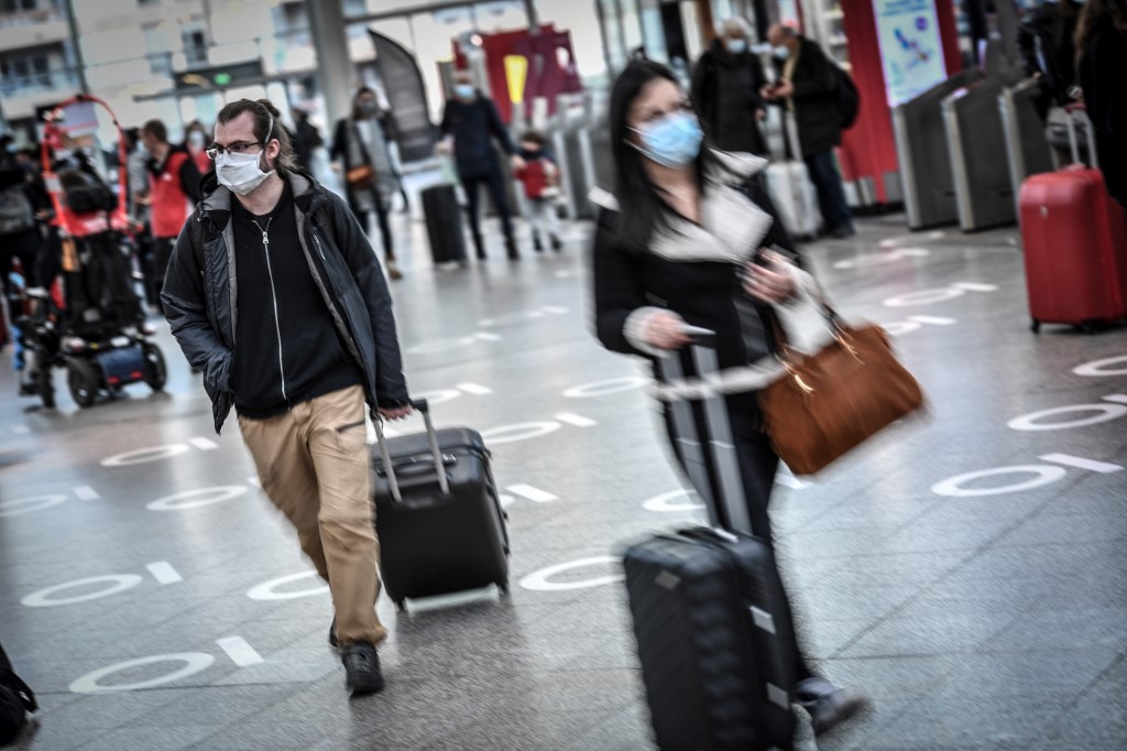 Les voyageurs tirent leurs valises dans le hall des départs de la gare de Lyon à Paris, le 18 décembre 2020. (AFP)