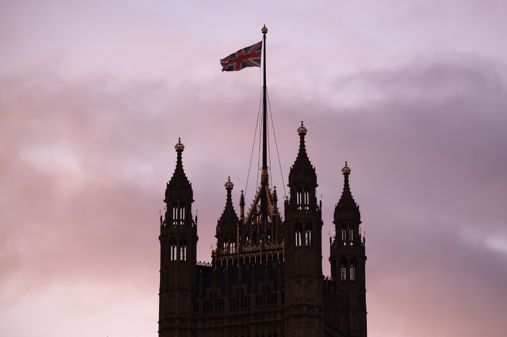 Le drapeau du Royaume-Uni vole du haut de la tour Victoria au palais de Westminster, qui abrite les chambres du Parlement, à Londres. (AFP)