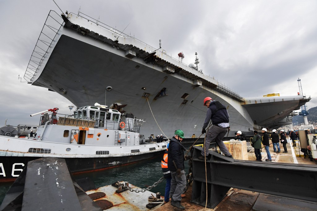 Des hommes travaillent à côté du porte-avions nucléaire français Charles de Gaulle dans le chantier naval de Toulon, dans le sud de la France, le 8 février 2017. (AFP)