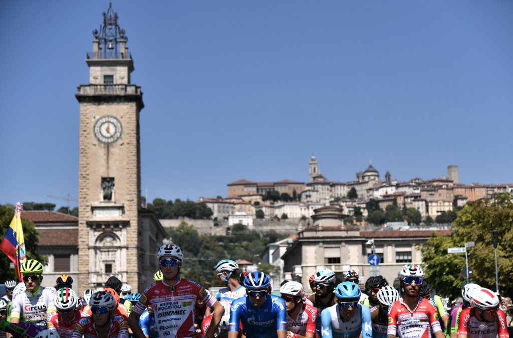 Les coureurs s'arrêtent pour une minute de silence pour les victimes de la pandémie COVID-19 avant le début de la 114e édition du giro di Lombardia (Tour de Lombardie), une course cycliste de 231 km de Bergame à Côme, le 15 août 2020. (AFP)