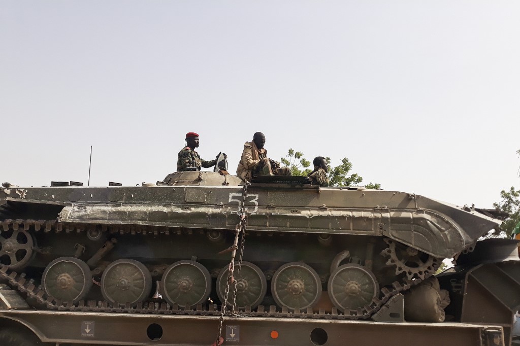 Un soldat de l'armée tchadienne est assis au sommet d'un char qui est transporté sur un camion à N'Djamena, le 3 janvier 2020. (AFP)