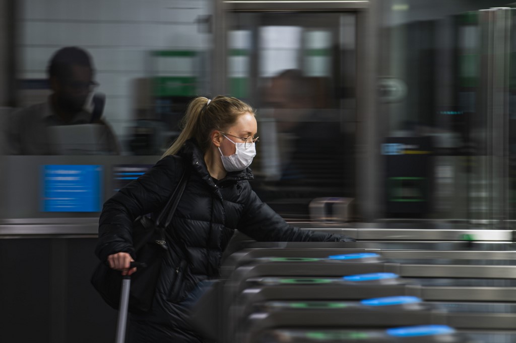 Une banlieusarde tôt le matin dans le métro de Stockholm porte un masque facial alors qu'une recommandation est entrée en vigueur le 7 janvier 2021 de l'agence de santé publique du pays de porter les revêtements pendant les heures de pointe du matin et du soir dans le but de freiner la propagation de Covid-19. (AFP)