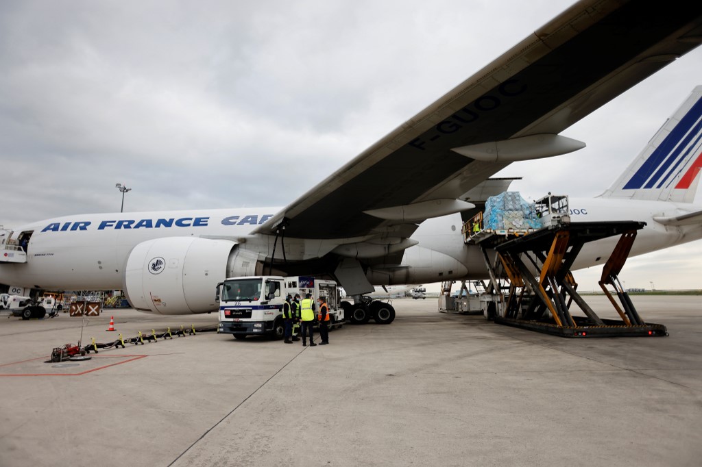 Des employés chargent un conteneur pharmaceutique dans un avion cargo d'Air France à l'aéroport de Roissy, au nord de Paris, le 25 novembre 2020. (AFP)