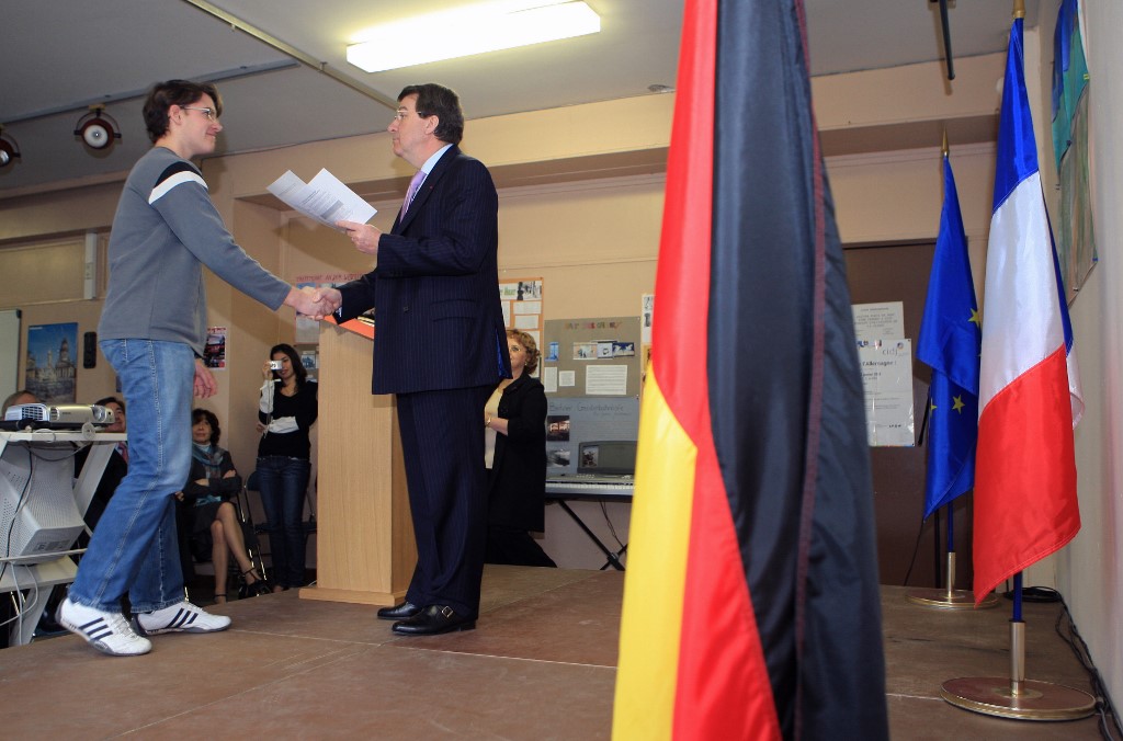 Le ministre de l'Éducation de l'époque, Xavier Darcos (Droite), serre la main d'un étudiant, Quentin Boutenet, alors qu'il lui décerne le diplôme de langue et littérature allemandes dans le cadre de la journée franco-allemande, le 22 janvier 2008 au lycée Richelieu à Rueil-Malmaison, en dehors de Paris. (AFP)