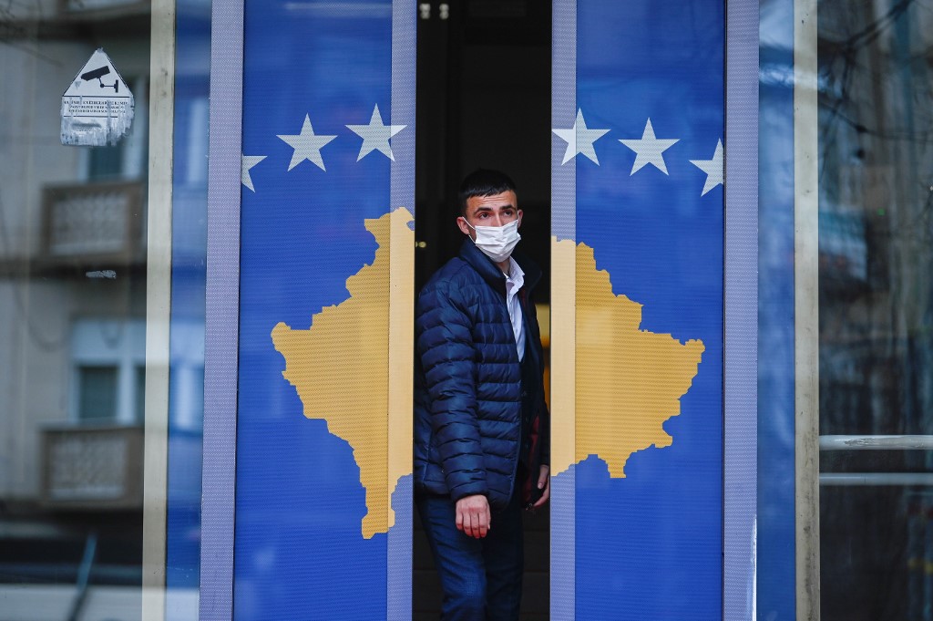 Un homme sort d'un bâtiment gouvernemental décoré du drapeau du Kosovo à Pristina, le 22 décembre 2020. (AFP)