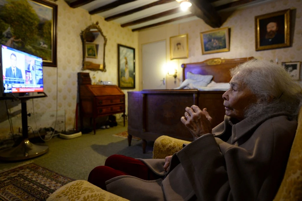 Renee Bodin, 93 ans, regarde le discours télévisé du réveillon du nouvel an du président français Emmanuel Macron dans sa chambre à Happonvilliers, dans le centre de la France, le 31 décembre 2020. (AFP)