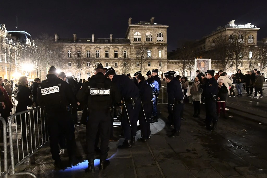 La police effectue des recherches sur les visiteurs alors qu'ils accèdent à un périmètre de sécurité devant la cathédrale Notre-Dame dans le centre de Paris la veille de Noël, le 24 décembre 2016, avant la messe de minuit. (AFP)