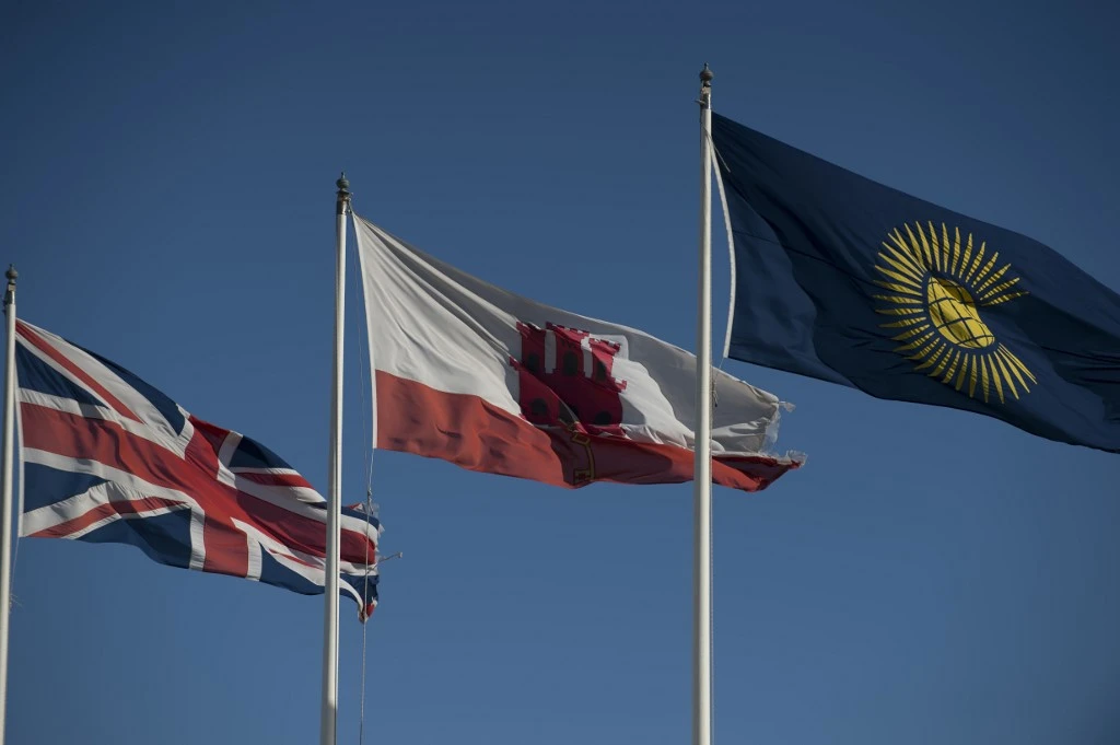 Le drapeau de Gibraltar (C) et l'Union Jack (L) vole à Gibraltar le 1er janvier 2021. Gibraltar fera partie de la zone sans passeport de l'Europe pour maintenir la fluidité de la circulation à sa frontière avec l'Espagne dans le cadre d'un accord historique conclu quelques heures avant la Grande-Bretagne a quitté l'union douanière et le marché unique de l'UE. (JORGE GUERRERO / AFP)