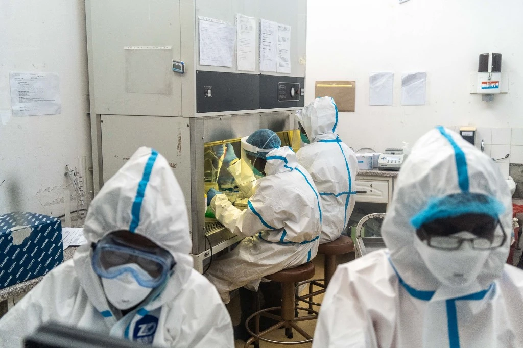 Des membres de l'Université nationale des sciences et technologies (NUST) travaillent dans un centre de test de laboratoire COVID-19. (AFP)