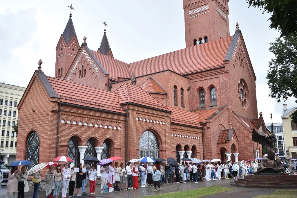 Les femmes forment une chaîne humaine à l'extérieur de l'Église catholique des Saints Simon et Helena pour protester contre la violence policière lors de récents rassemblements de partisans de l'opposition contre les résultats contestés des élections présidentielles à Minsk, le 27 août 2020. (AFP)