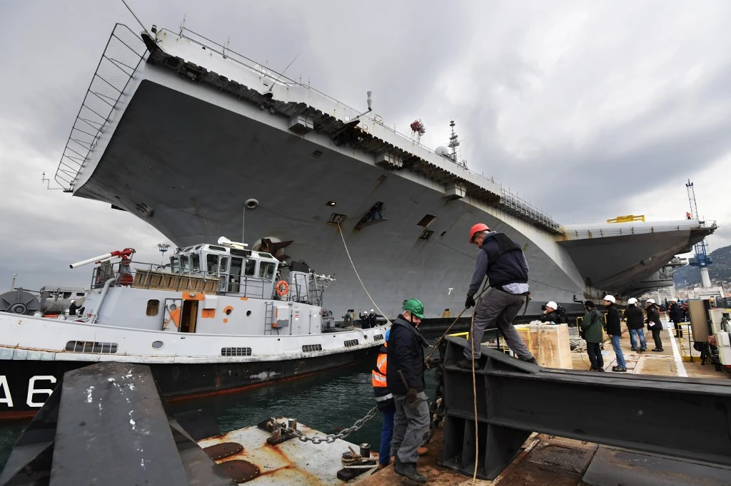Des hommes travaillent à côté du porte-avions nucléaire français Charles de Gaulle dans le chantier naval de Toulon, dans le sud de la France, le 8 février 2017. (AFP)
