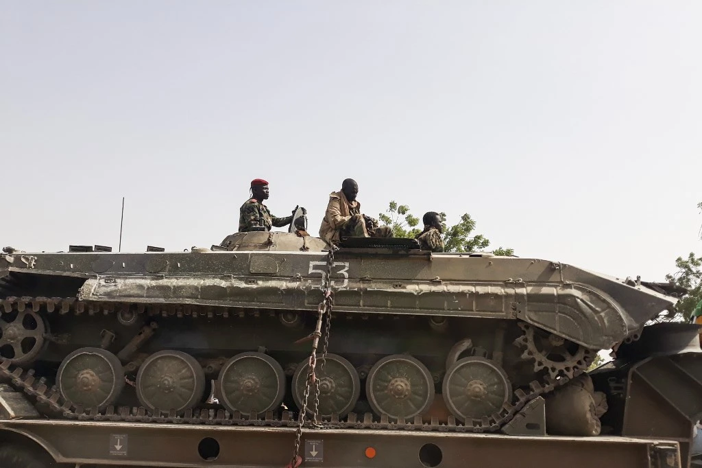 Un soldat de l'armée tchadienne est assis au sommet d'un char qui est transporté sur un camion à N'Djamena, le 3 janvier 2020. (AFP)