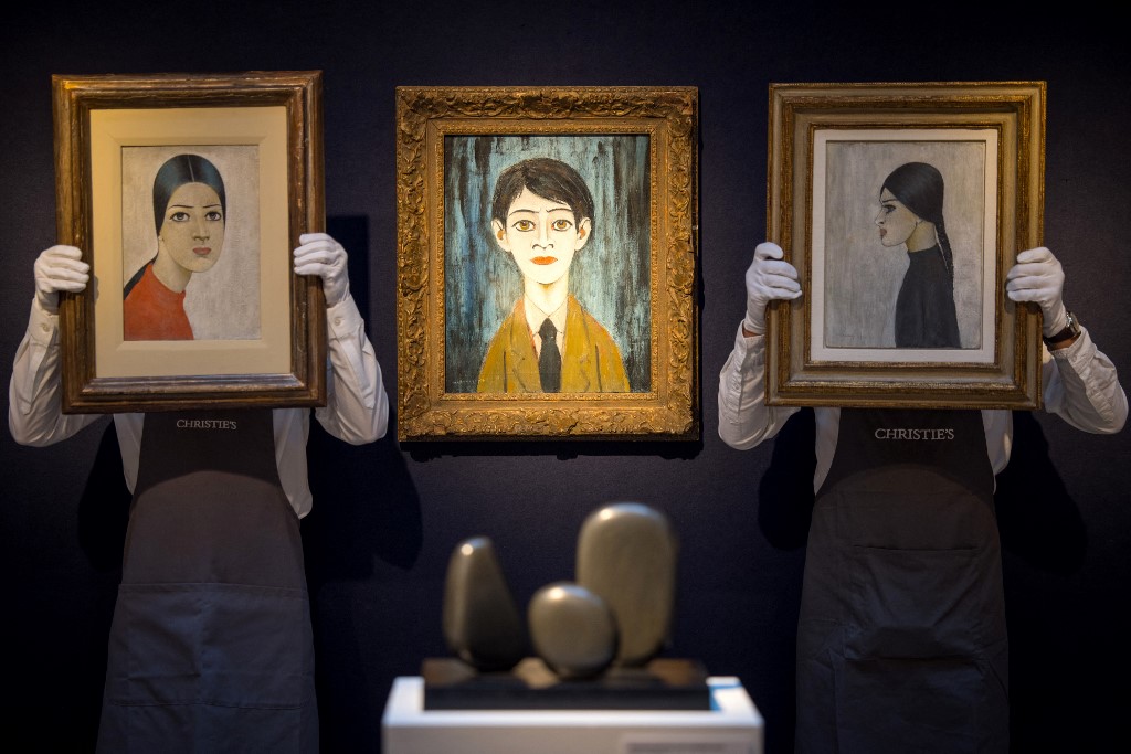 Des employés de galerie posent avec des œuvres d'art. (Photo, AFP/Archives)