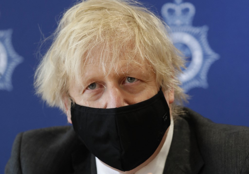 Le Premier ministre britannique Boris Johnson écoute une question lors d'une visite au quartier général de la police du sud du Pays de Galles à Bridgend, dans le sud du Pays de Galles, le 17 février 2021. (Photo, AFP)