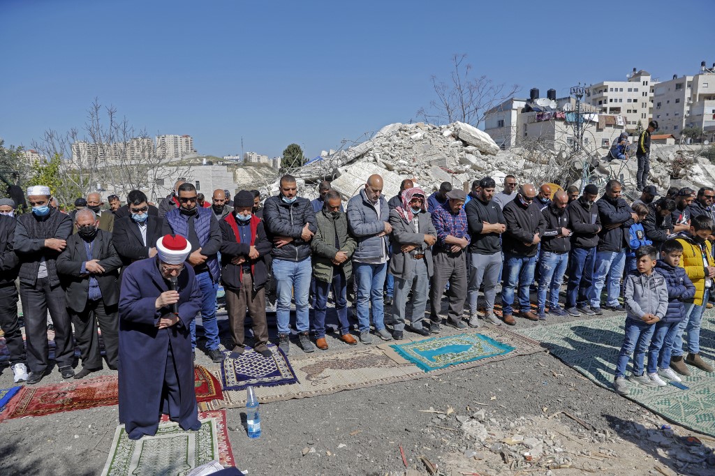 Des fidèles musulmans palestiniens assistent à la prière du vendredi midi devant les décombres des bâtiments démolis par les employés de la municipalité de Jérusalem, dans le quartier à majorité arabe de Jérusalem-Est, Issawiya, le 26 février 2021. (Photo, AFP)