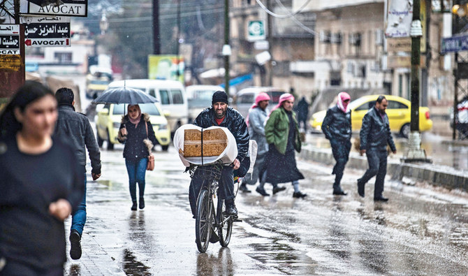 Quelques personnes vaquent à leurs occupations alors que les magasins sont fermés dans la ville de Qamishli, à majorité kurde, dans le nord-est de la Syrie, dans un climat de tensions accrues avec les manifestants pro-régime. (AFP)