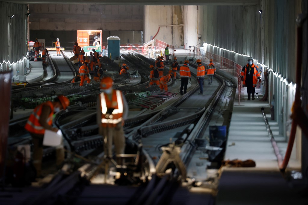 Les ouvriers des groupes de construction Colas et Alstom travaillent à l'aménagement des voies ferrées des futures lignes de métro 15 et 16, partie du réseau de métro Grand Paris Express en construction, à proximité de la future station Noisy-Champs, le 29 octobre 2020 à Champs -sur-Marne, à l'extérieur de Paris. (Photo, AFP)