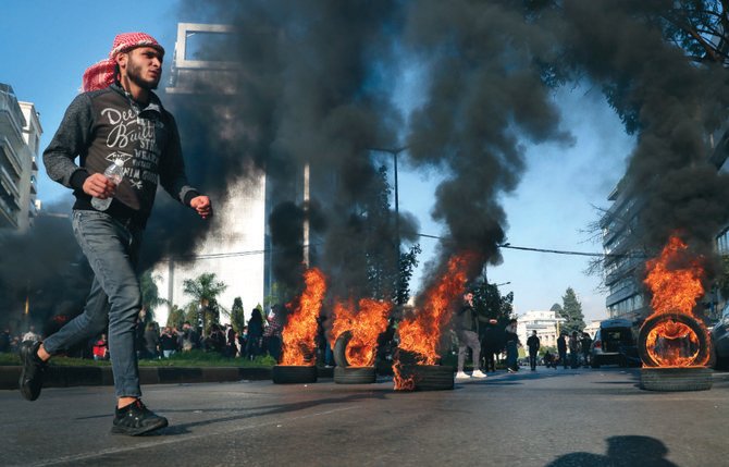 Des manifestants brûlent des pneus pour bloquer une route mercredi, lors d'une manifestation appelant à la libération des militants anti-gouvernementaux à Beyrouth, au Liban. (Photo, AP)