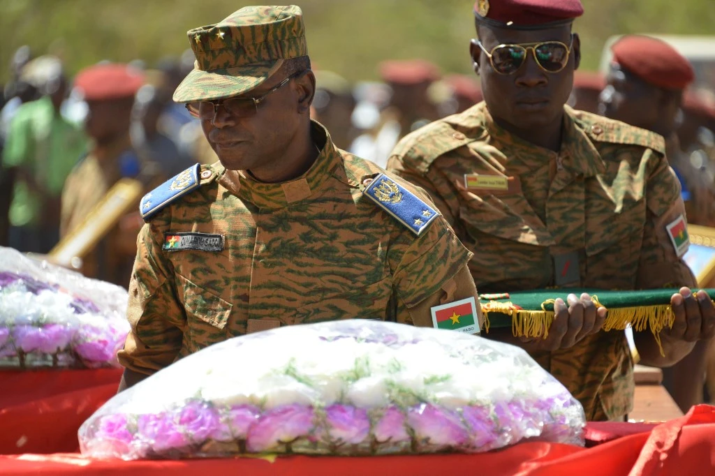 Le chef d'état-major de l'armée burkinabè Oumarou Sadou (à gauche) récompense à titre posthume les huit soldats tués lors des deux attaques dans la capitale du pays lors d'une cérémonie d'inhumation, le 7 mars 2018 à Ouagadougou. (Photo, AFP)
