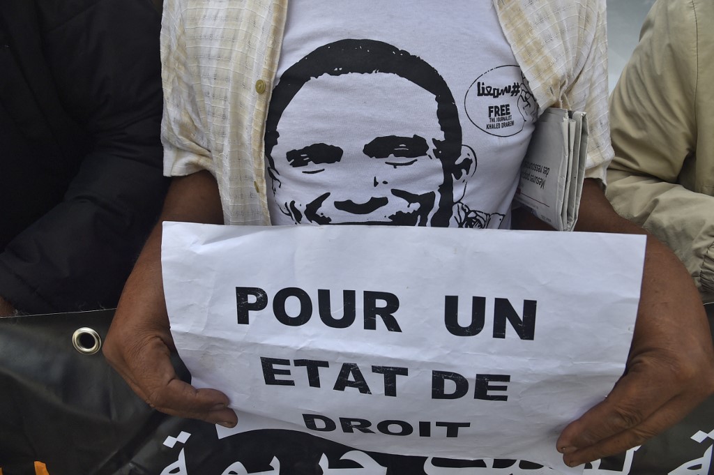 Un manifestant algérien lève une pancarte qui dit "pour l'Etat de droit" lors d'un rassemblement hebdomadaire pour appeler à la libération du journaliste emprisonné Khaled Drareni et exprimer son soutien à la liberté de la presse, dans la capitale Alger, le 12 octobre 2020. RYAD KRAMDI / AFP