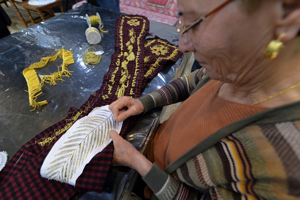 Karjiya Baqtar brode un précieux châle de prière à l'aide de fil d'or, pour l'offrir au pape François lors de sa prochaine visite dans sa ville irakienne de Qaraqosh, dans la province de Ninive, à environ 30 kilomètres de Mossoul, le 4 mars 2021. Zaid AL-OBEIDI / AFP