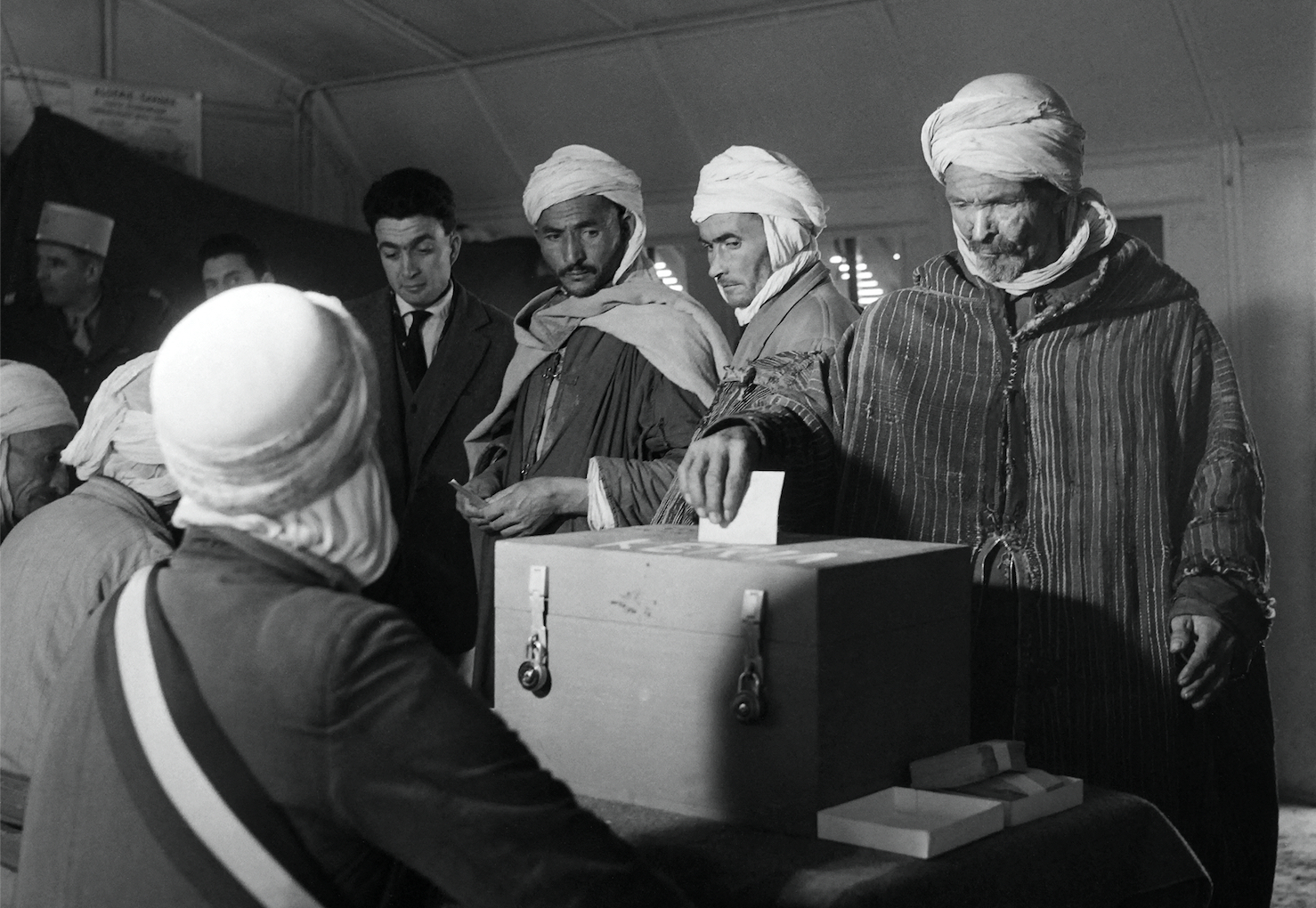 Les Algériens et les Européens d'Algérie déposent leur bulletin de vote pour le référendum sur l'autodétermination de l'Algérie dans les urnes du bureau de vote de Kéria, près de Tiaret, le 8 janvier 1961, pendant la guerre d'Algérie. Le président de Gaulle a décidé le référendum dans l'espoir de mettre fin au conflit qui avait débuté en novembre 1954 pour l'indépendance de l'Algérie. Jacques Landry / AFP