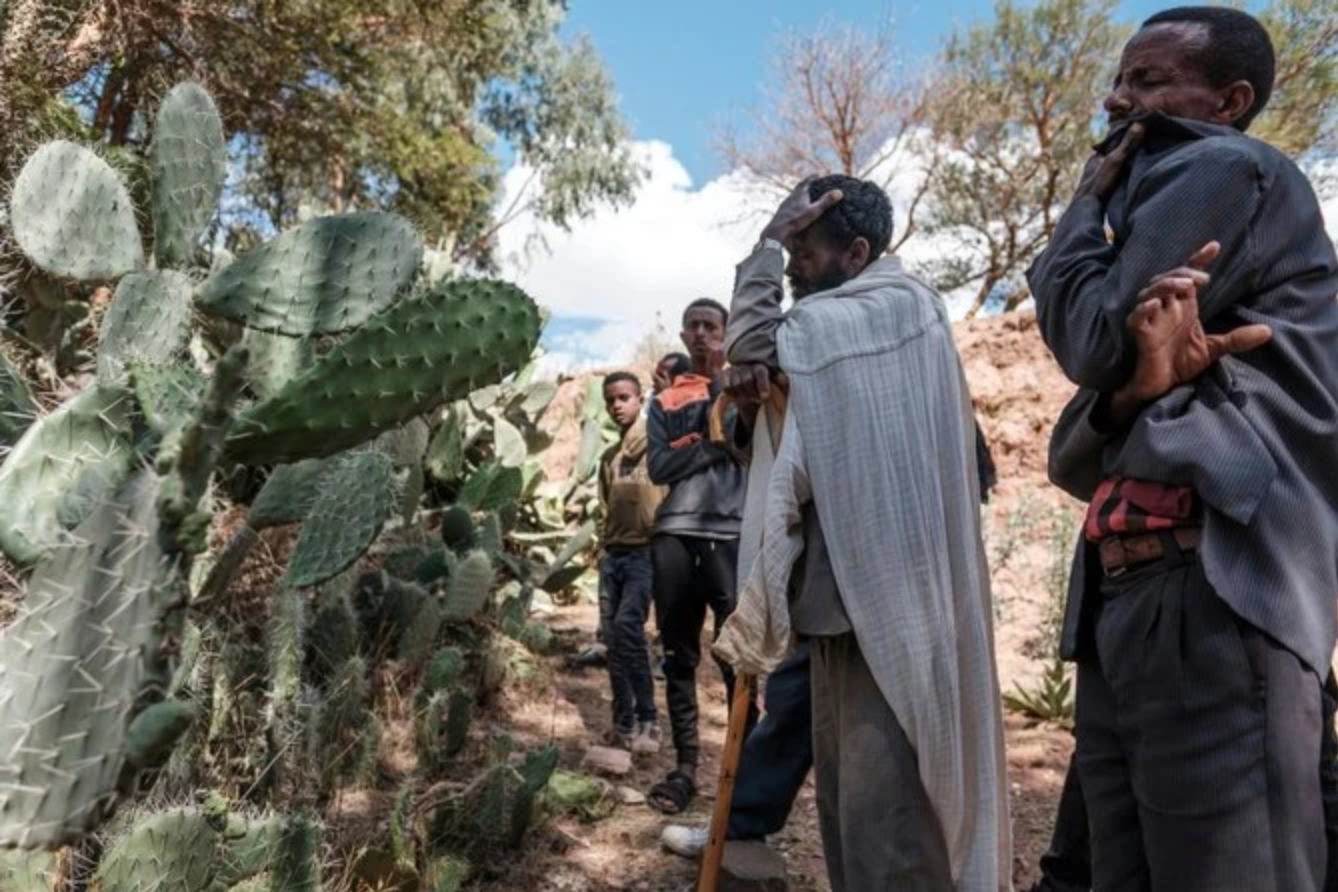Des gens pleurent devant une fosse commune les victimes d'un massacre qui aurait été perpétré par des soldats érythréens voisins dans le village de Dengolat, au nord de Mekele, la capitale du Tigré, le 26 février 2021 (AFP)