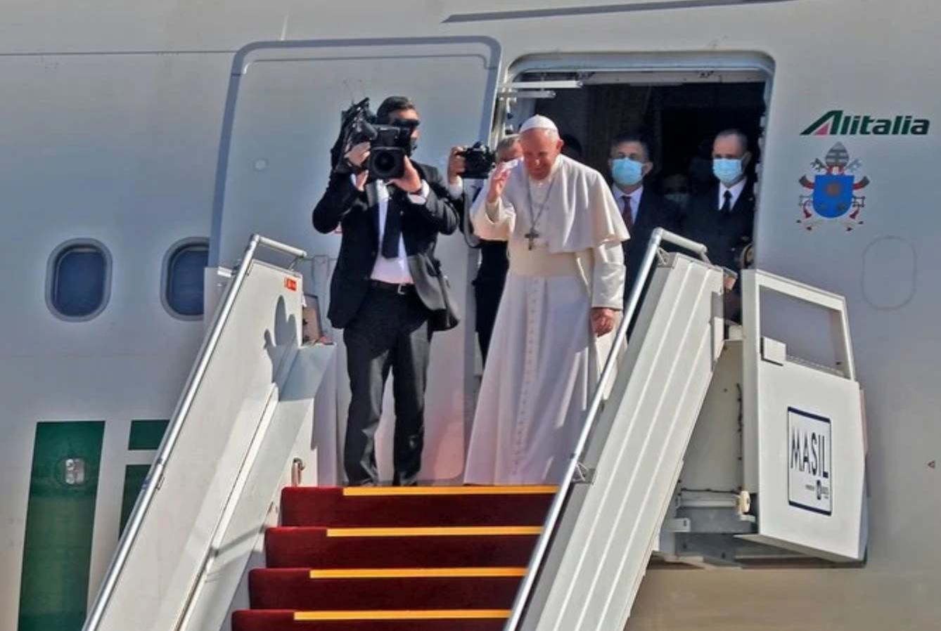 Le pape François salue ses hôtes avant de monter à bord de son Airbus A330 d'Alitalia au départ de l'aéroport international de Bagdad, la capitale irakienne, le 8 mars 2021. (AFP)