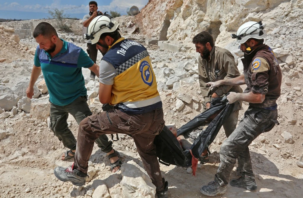 Cette photo prise à Kafr Ain le 7 septembre 2018 montre des membres de la défense civile syrienne, également connus sous le nom de «Casques blancs», portant une victime après des frappes aériennes, à quatre kilomètres à l'est de Khan Sheikhoun dans la campagne du sud de la province d'Idlib. Anas AL-DYAB / AFP